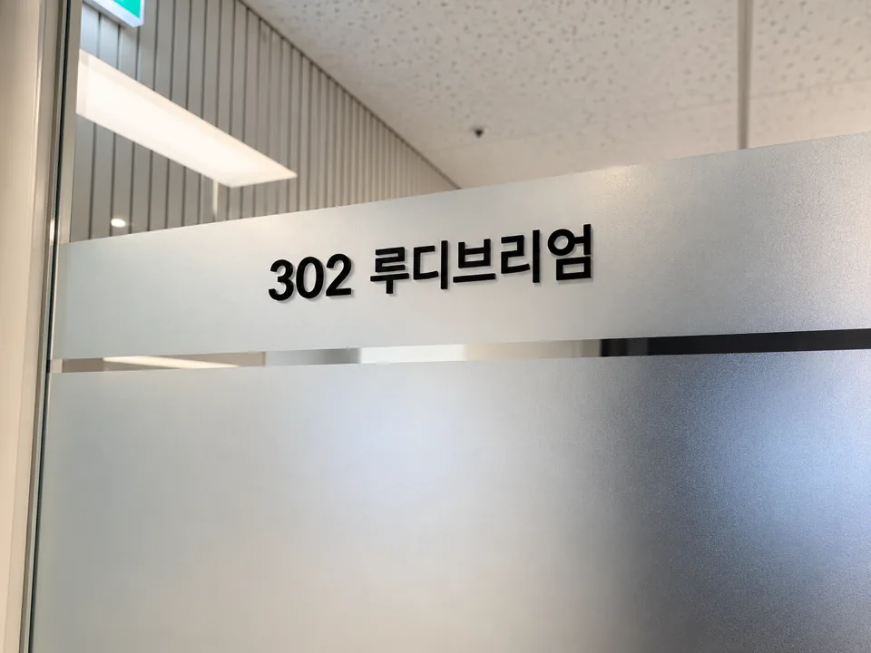 ‘302 루디브리엄’ 문패가 붙은 반투명 유리 회의실 벽
